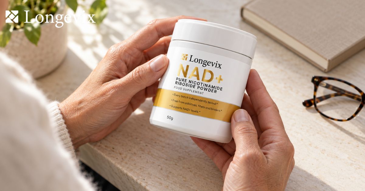 Hands checking the Longevix nicotinamide riboside powder label beside a notebook